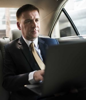 businessman-inside-a-car-working-on-his-laptop.jpg
